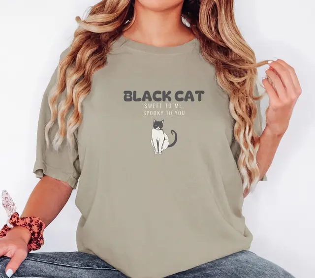 Person wearing a Khaki tee printed with BLACK CAT, SWEET TO ME, SPOOKY TO YOU