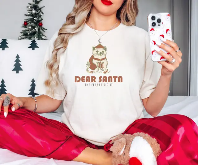 Person wearing a Ivory tee printed with DEAR SANTA, THE FERRET DID IT