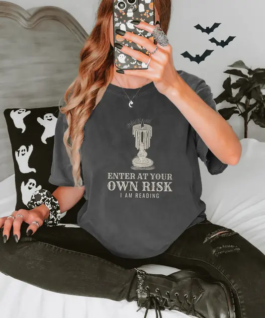 Person wearing a Pepper tee printed with ENTER AT YOUR OWN RISK, I AM READING