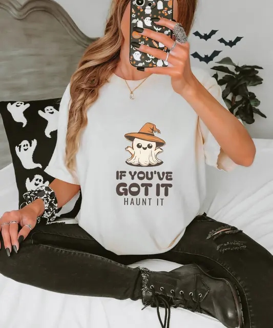 Person wearing a Ivory tee printed with IF YOU'VE GOT IT, HAUNT, IT