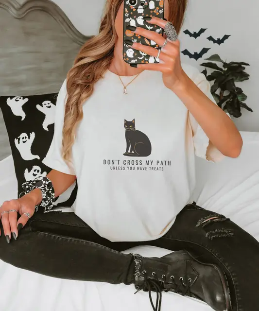 Person wearing a Ivory tee printed with DON'T CROSS MY PATH, UNLESS YOU HAVE TREATS