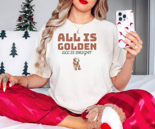 Person wearing a Ivory tee printed with ALL IS GOLDEN, ALL IS BRIGHT