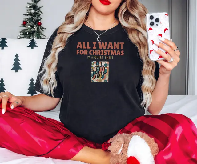 Person wearing a Black tee printed with ALL I WANT FOR CHRISTMAS, IS A QUIET SHIFT