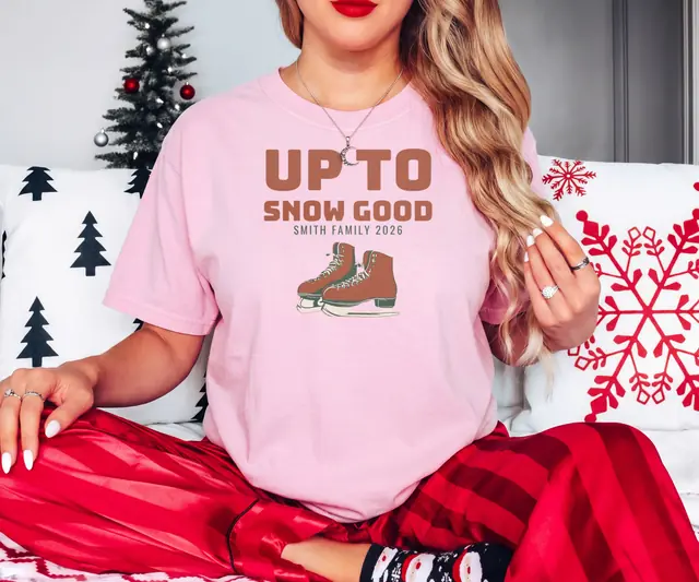 Person wearing a Blossom tee printed with UP TO SNOW GOOD, SMITH FAMILY 2026