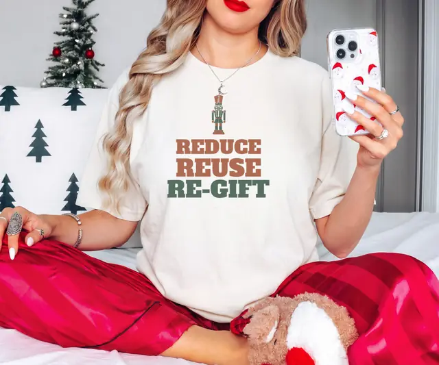 Person wearing a Ivory tee printed with REDUCE, REUSE, RE-GIFT