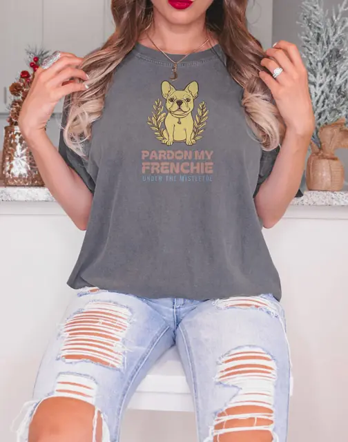 Person wearing a Pepper tee printed with PARDON MY FRENCHIE, UNDER THE MISTLETOE