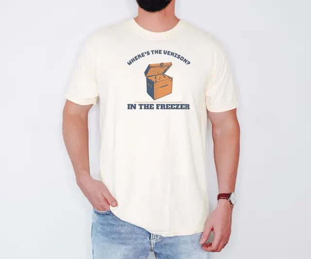 Person wearing a Ivory tee printed with WHERE'S THE VENISON?, IN THE FREEZER