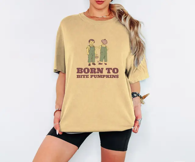 Person wearing a Butter tee printed with BORN TO BITE PUMPKINS