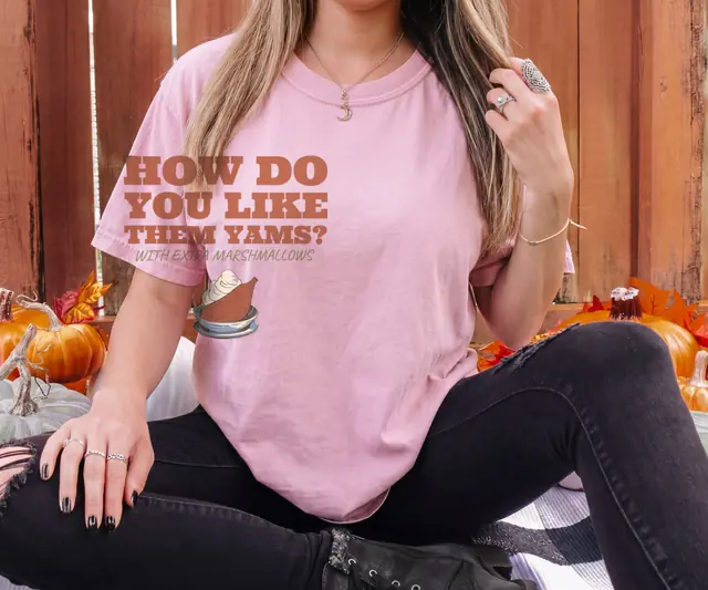 Person wearing a Blossom tee printed with HOW DO YOU LIKE THEM YAMS?, WITH EXTRA MARSHMALLOWS