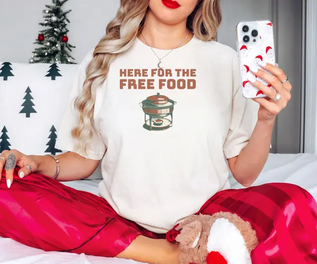 Person wearing a Ivory tee printed with HERE FOR THE FREE FOOD